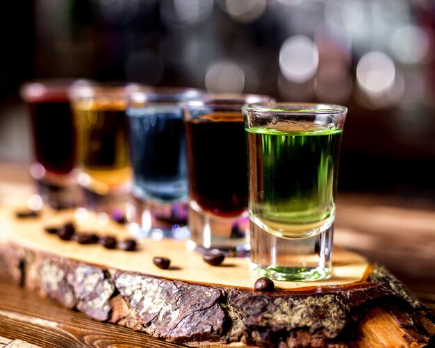 Side view multi-colored shots with coffee beans on a piece of wood