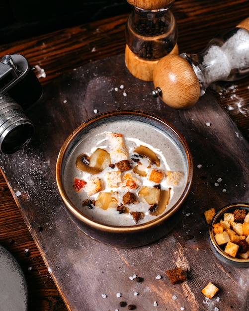 Side view of mushroom cream soup with toasts in bowl