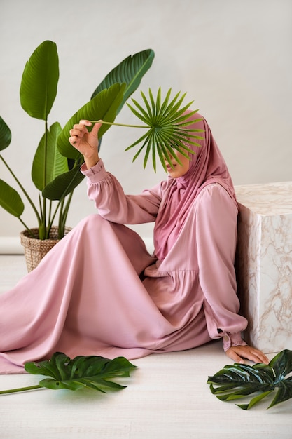 Free Photo side view muslim woman holding leaf