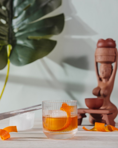 Side view of negroni cocktail glass with orange peel on the table