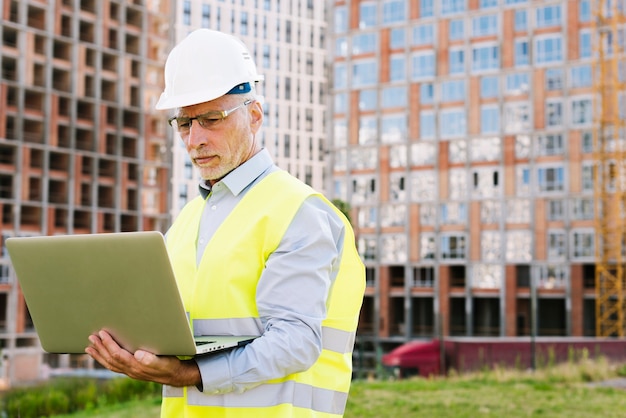 Free Photo side view old man with laptop outdoors