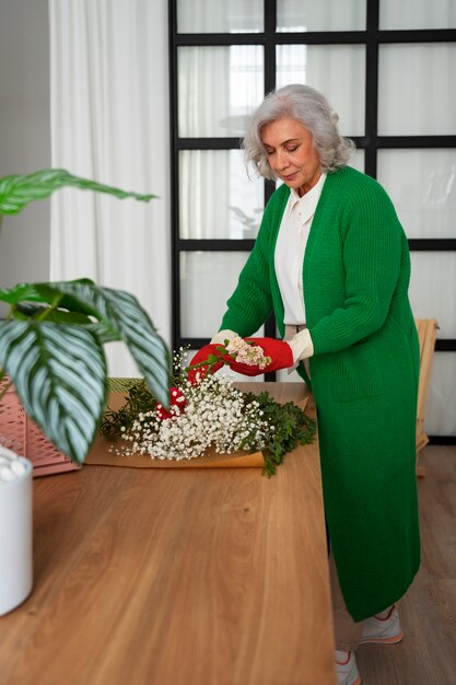 Side view old woman taking care of plants