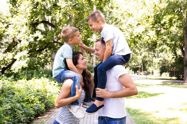 Side view of parents carrying their children