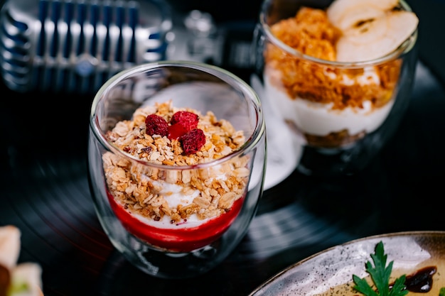 Free photo side view parfait with yogurt muesli and raspberry