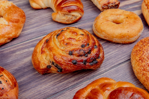 side view of pattern of different bakery products on wooden background