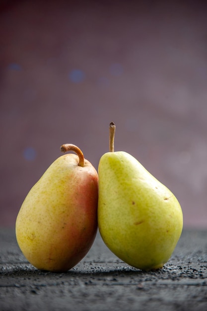 Side view pears on table two ripe green-yellow-red pears on the purple background