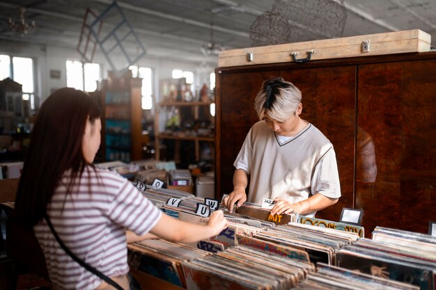 Side view people checking vinyl records at shop