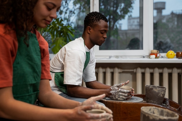 Side view people doing pottery