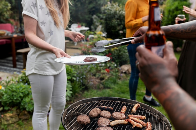 Free photo side view people making barbecue together