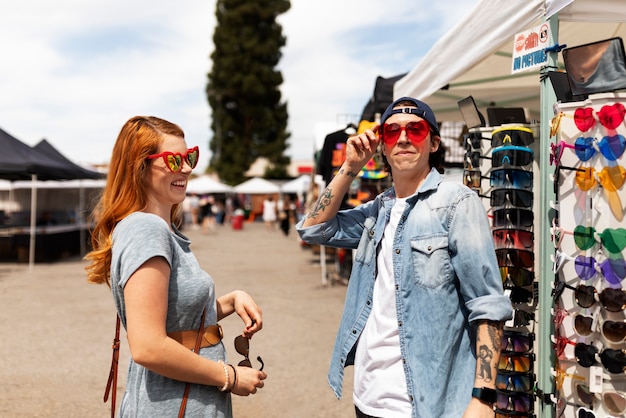 Free Photo side view people trying on sunglasses