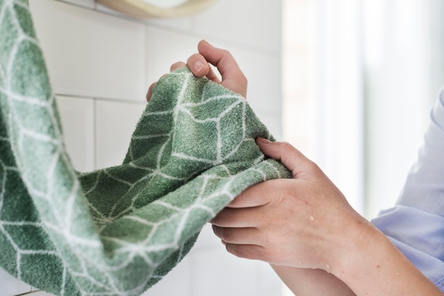 Free photo side view of person drying hands using towel