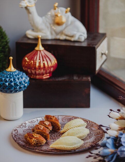 Side view of a plate with national azerbaijani pakhlava and shekarbura as novruz symbol