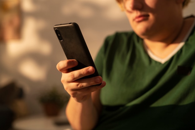 Side view plus-sized man holding smartphone