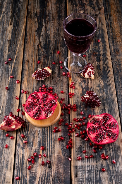 Free photo side view pomegranate seeds with glass of juice