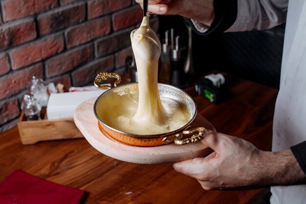 Side view of pouring cake mixture into a baking tin