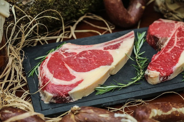 Side view raw meat for steak with rosemary on stand