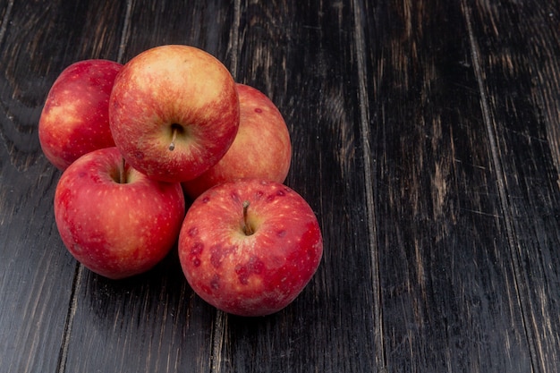 Side view of red apples on wooden surface with copy space