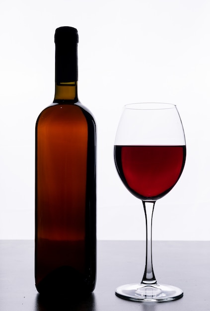 Free photo side view red wine with glass on white vertical