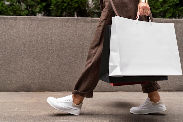 Side view rich woman carrying shopping bags