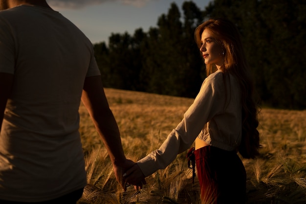 Free photo side view romantic couple holding hands