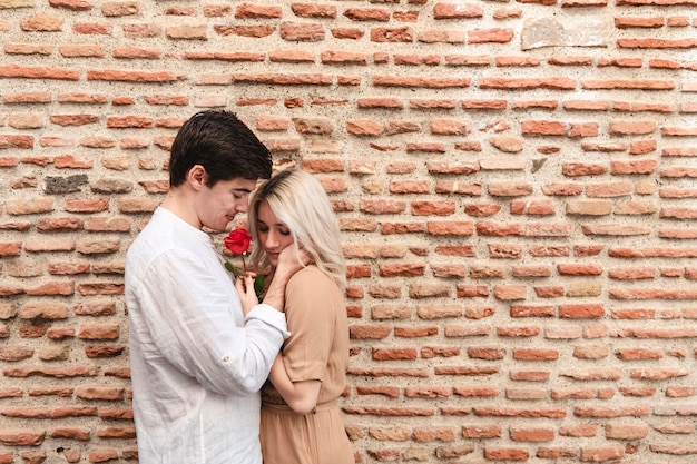 Free photo side view of romantic couple with rose