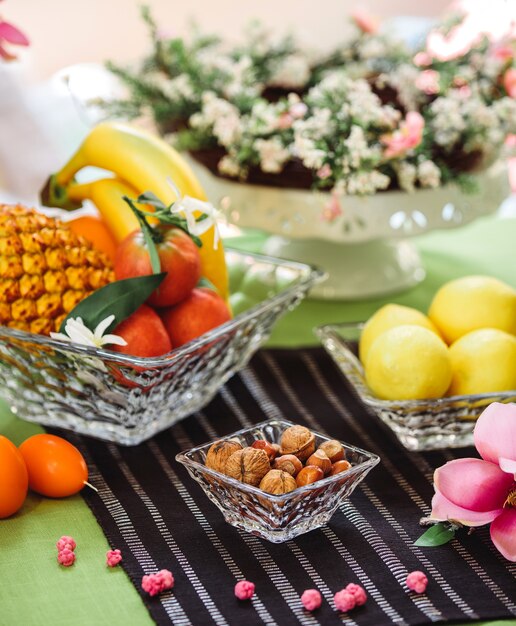 Side view rosette with nuts in the shell and a bowl of fruit and lemons on the table