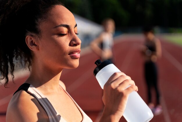 Side view runner holding a bottle of water