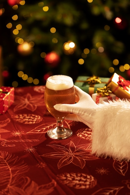 Free photo side view santa holding christmas beer