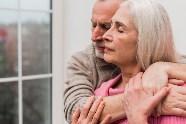 Side view senior couple hugging