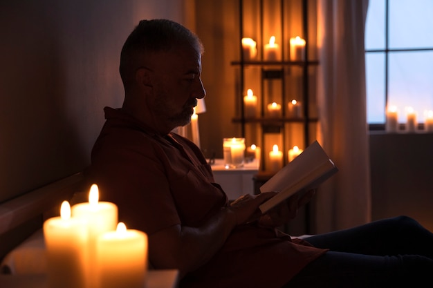 Side view senior man reading at home