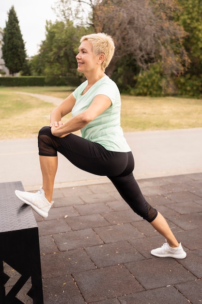 Side view of senior woman working out outside in the park