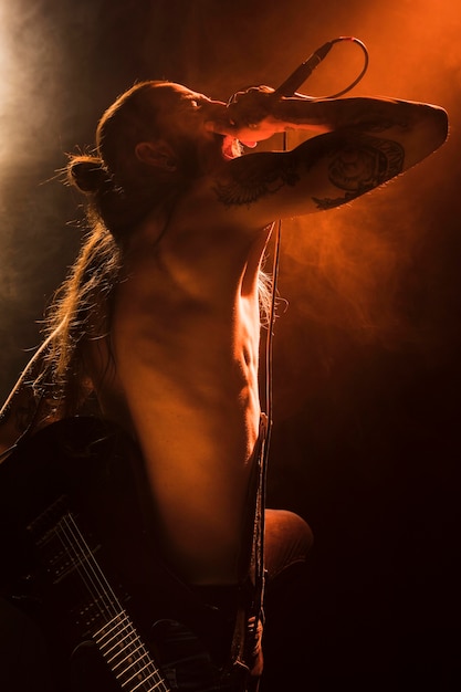 Free Photo side view shirtless man singing on stage