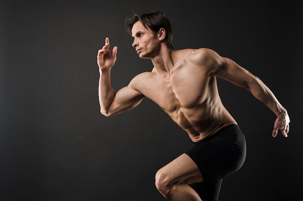 Free photo side view of shirtless muscled man posing