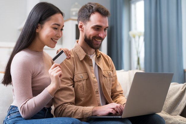 Side view of smiley couple shopping online