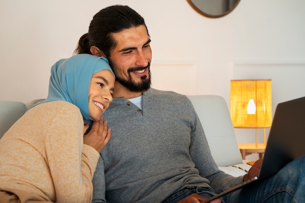 Side view smiley couple with laptop