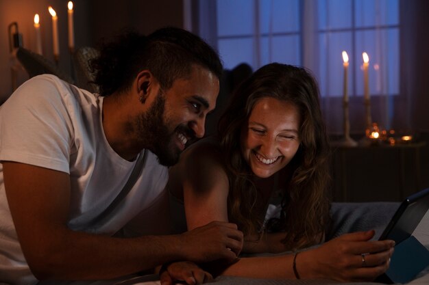 Side view smiley couple with tablet