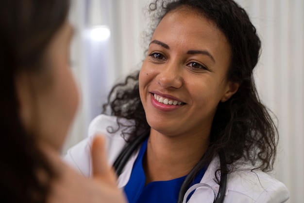 Free photo side view smiley doctor checking patient