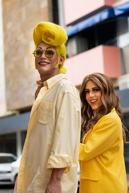 Free photo side view smiley drag queens posing