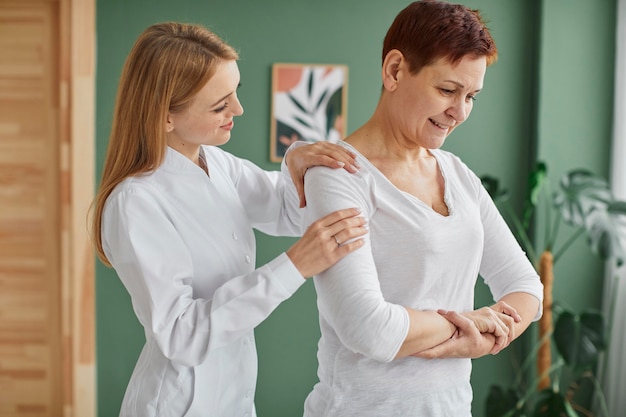 Side view of smiley elder woman in covid recovery doing physical exercises