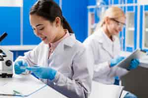 Free photo side view of smiley female scientists working in the lab