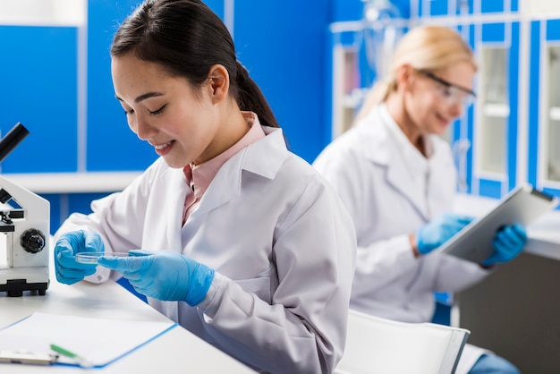 Free Photo side view of smiley female scientists working in the lab