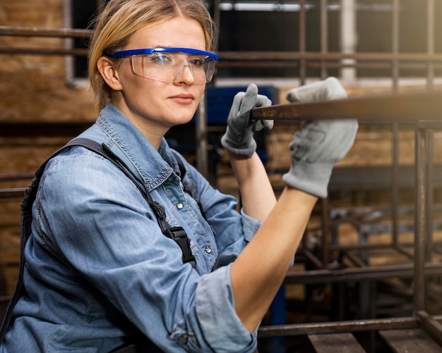 Free photo side view of smiley female welder at work