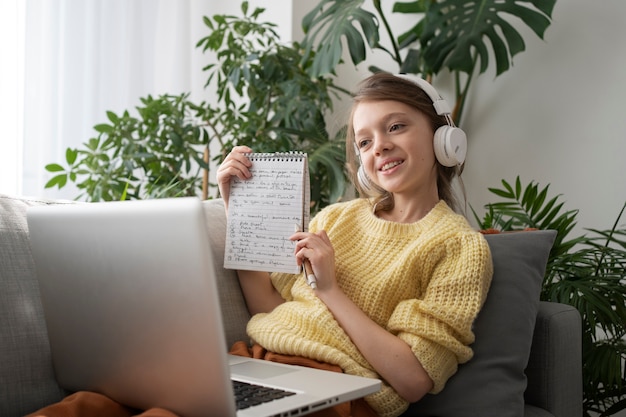 Free photo side view smiley girl holding notebook