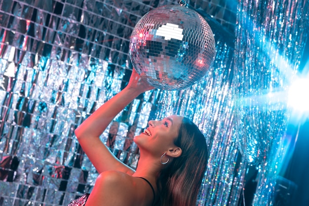 Side view smiley girl with disco ball