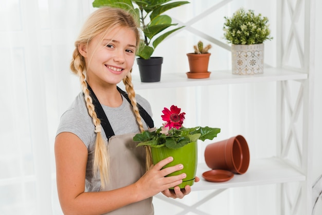 Side view smiley girl with flower pot