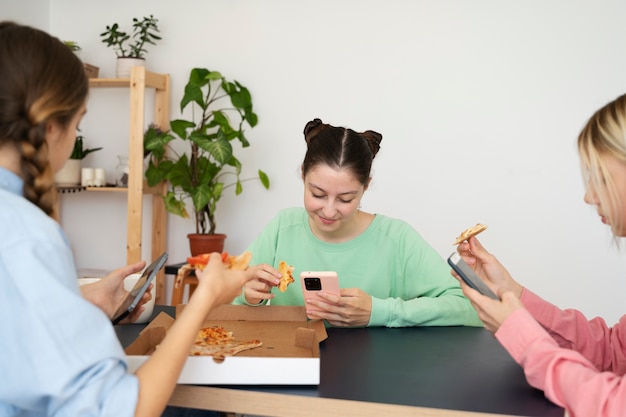 Free Photo side view smiley girls with smartphones