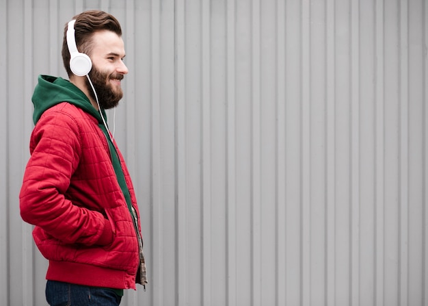 Free Photo side view smiley guy with beard and headphones