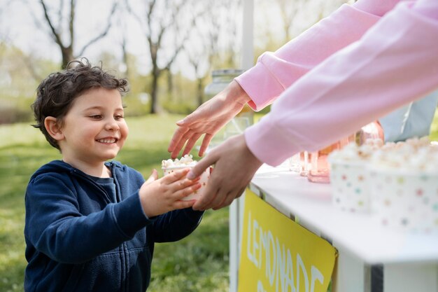 Side view smiley kid buying popcorn