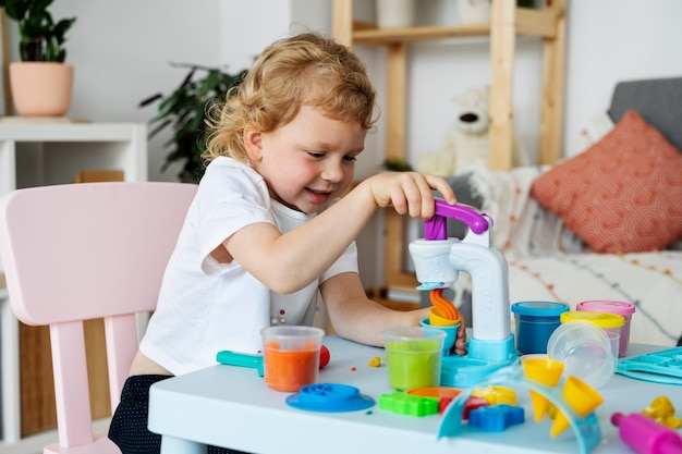 Free photo side view smiley kid playing indoors