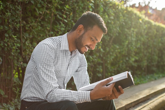 Free Photo side view smiley man holding book